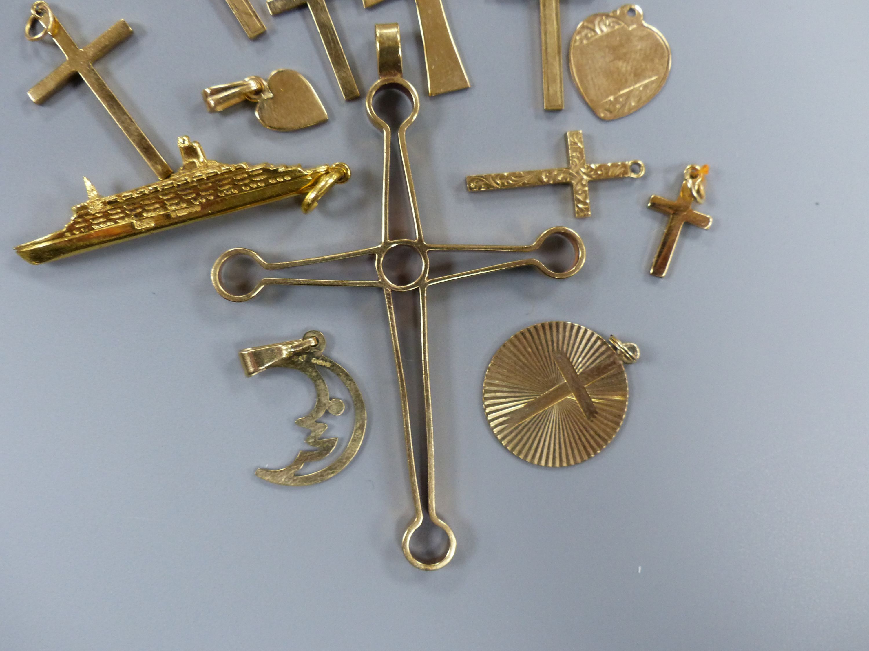 Fourteen assorted 9ct gold pendants including heart, QEII ship and crosses, largest 67mm,